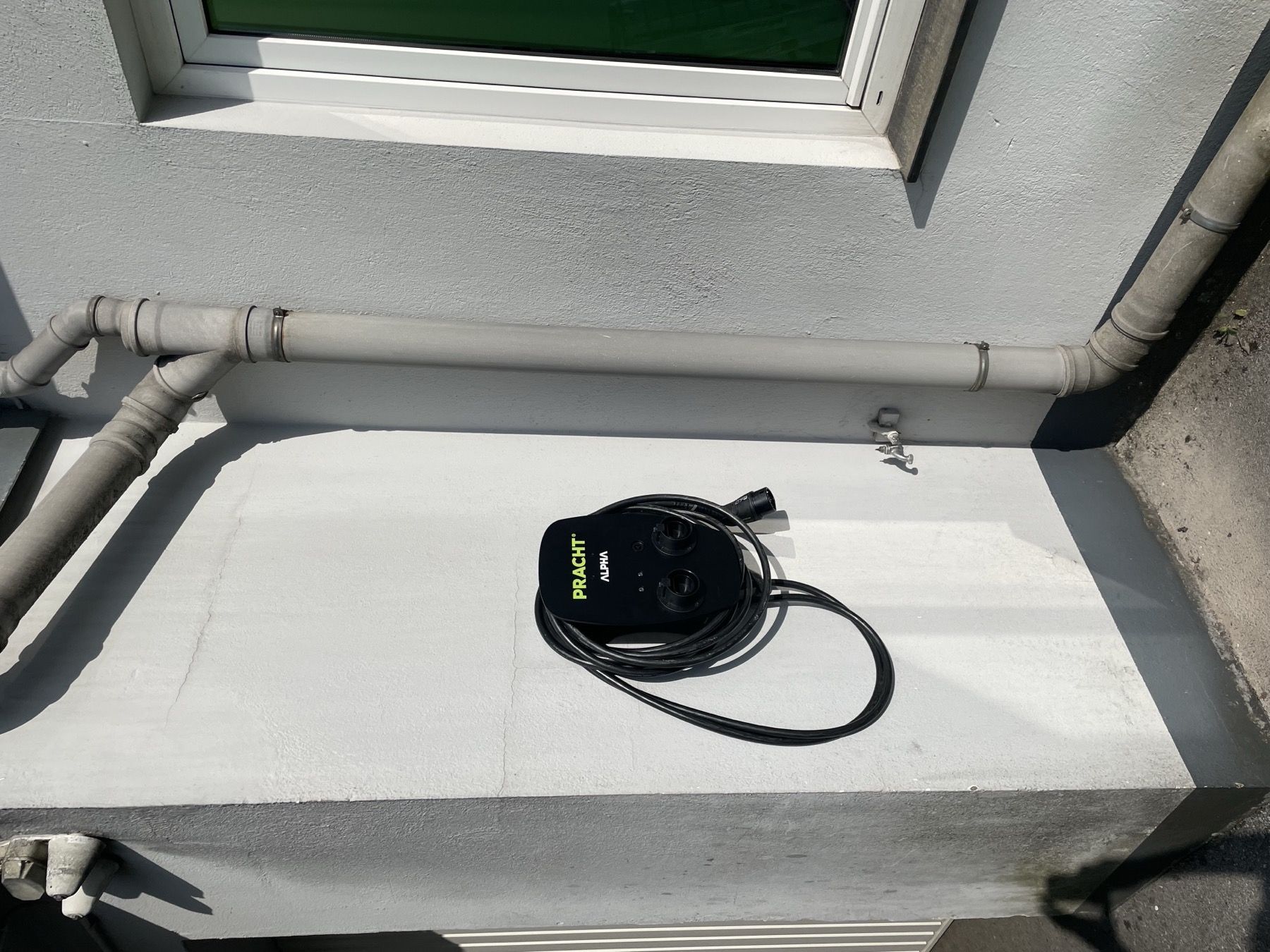Montierte Wallbox mit Ladekabel an der Außenwand